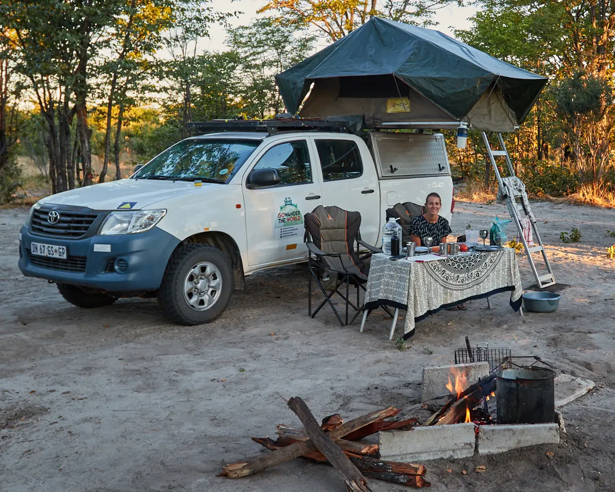 Ons kamp in Botswana tijdens ons reisjaar 2018: 4x4 met daktent, gedekte tafel en een kampvuur